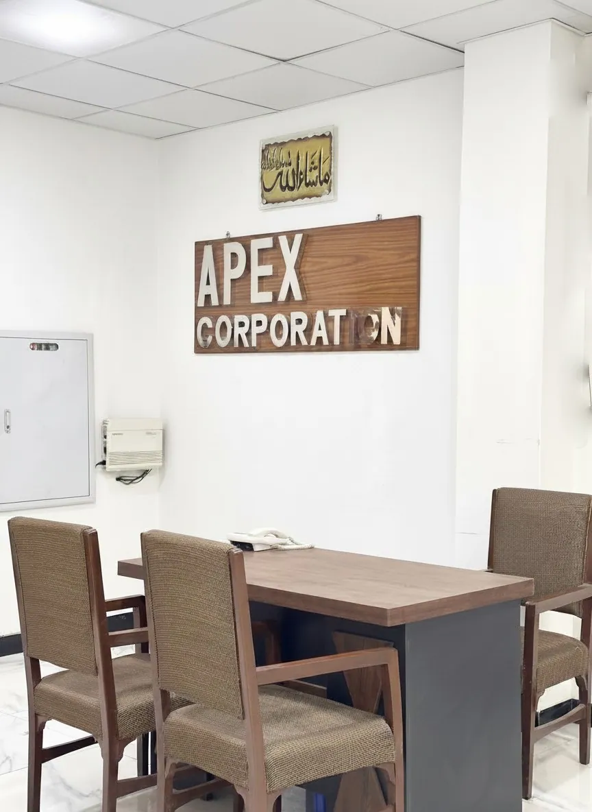 Reception area at Apex Corporation knitwear manufacturer office in North Karachi Industrial Area Pakistan with company sign and meeting table